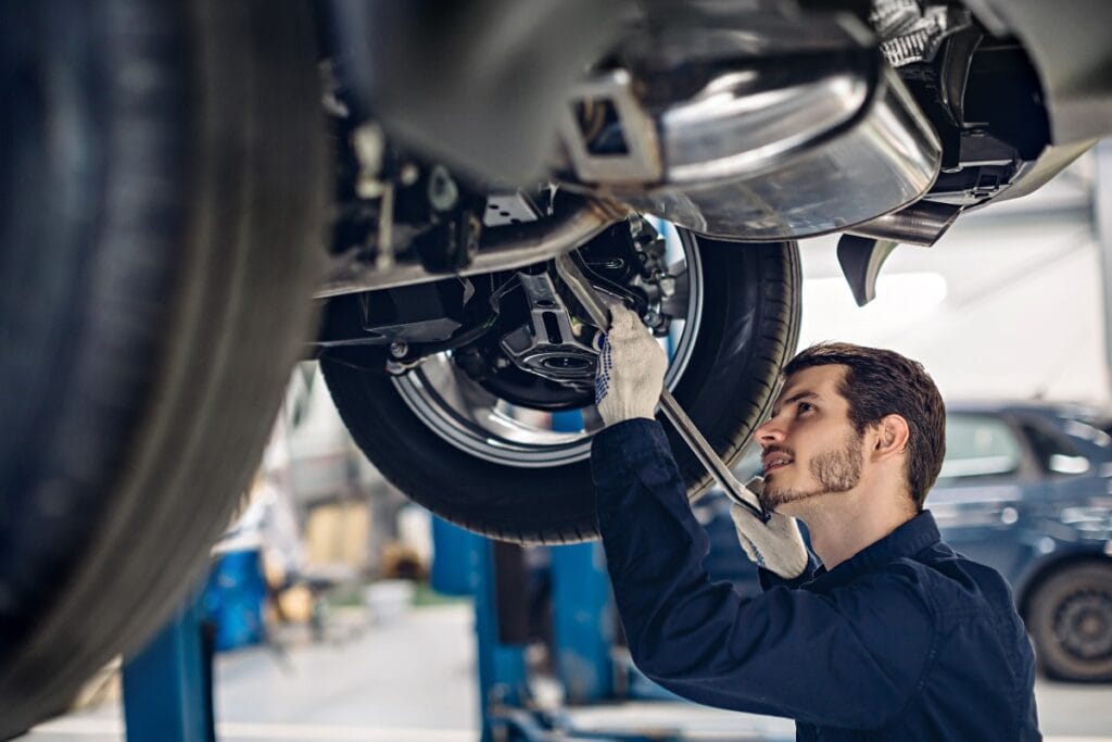 Auto car repair service center. Mechanic examining car suspension